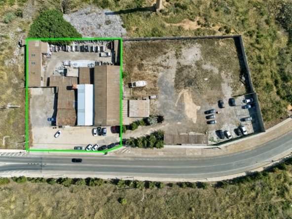 Vista aérea de nave industrial y solar con zona de aparcamiento en La Unión, Murcia — suelo libre junto a construcción existente.