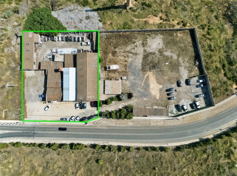 Vista aérea de nave industrial y solar con zona de aparcamiento en La Unión, Murcia — suelo libre junto a construcción existente.