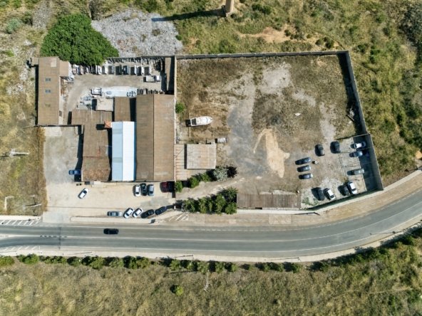 Vista aérea de nave industrial y solar con zona de aparcamiento en La Unión, Murcia — suelo libre junto a construcción existente.