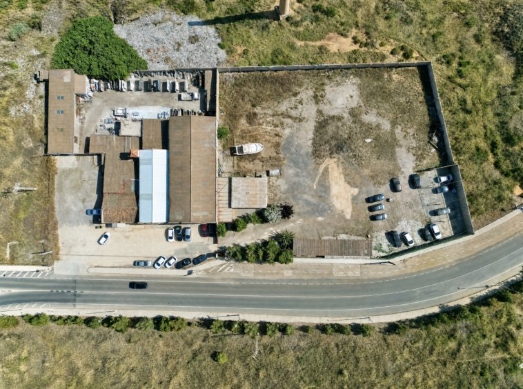 Vista aérea de nave industrial y solar con zona de aparcamiento en La Unión, Murcia — suelo libre junto a construcción existente.