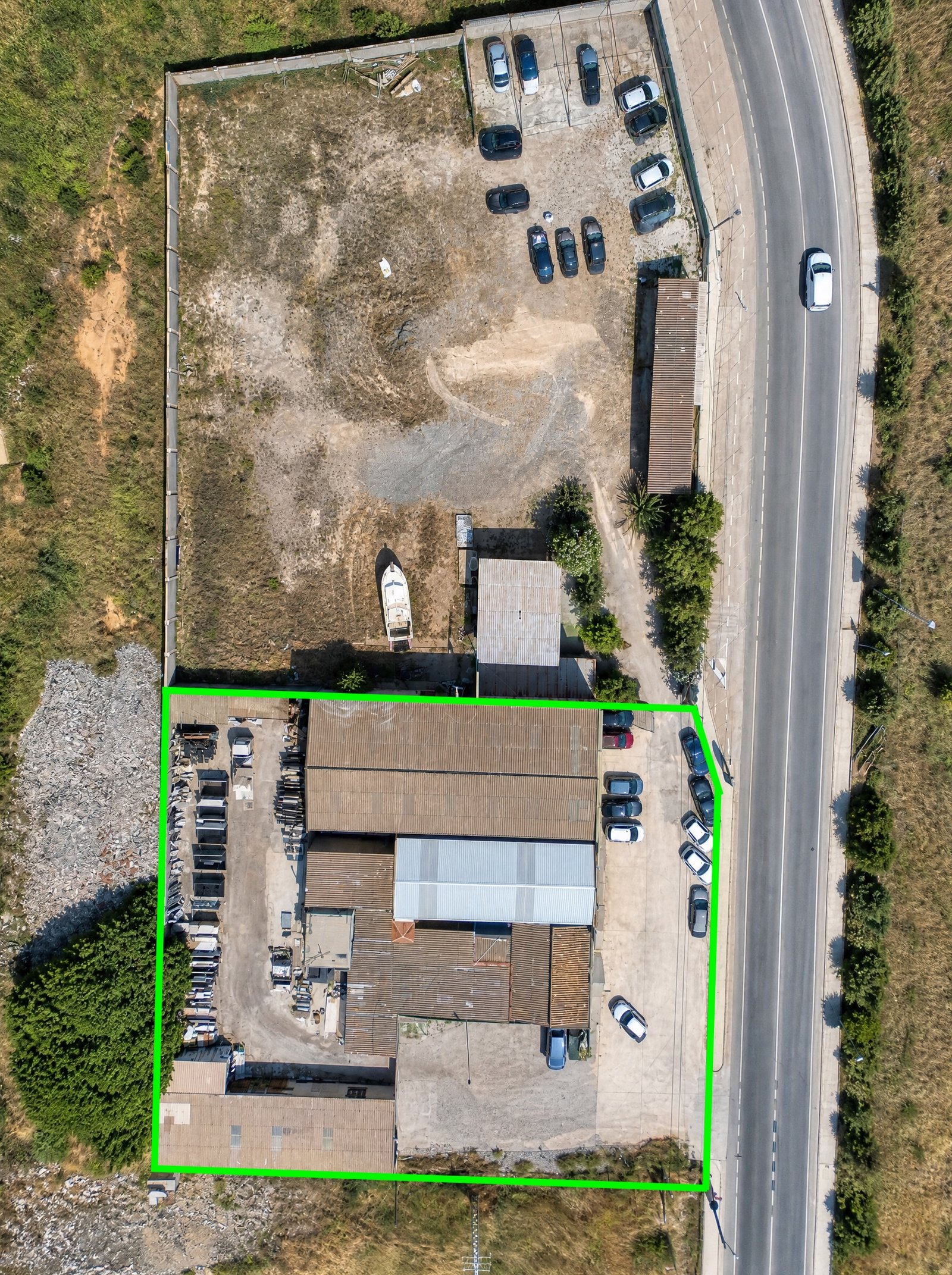 Vista aérea de nave industrial y solar con zona de aparcamiento en La Unión, Murcia — suelo libre junto a construcción existente.